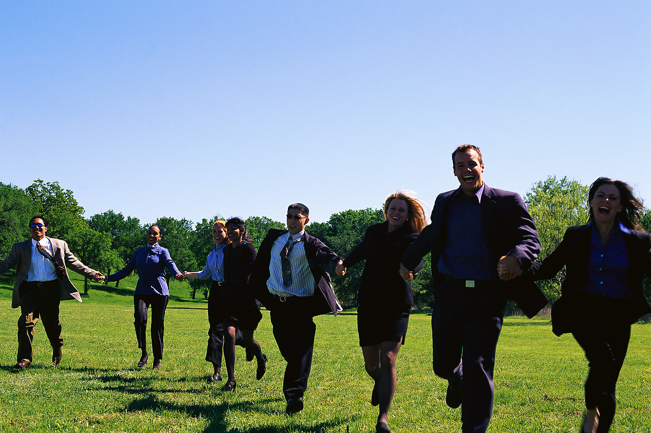 Group of people running holding hands