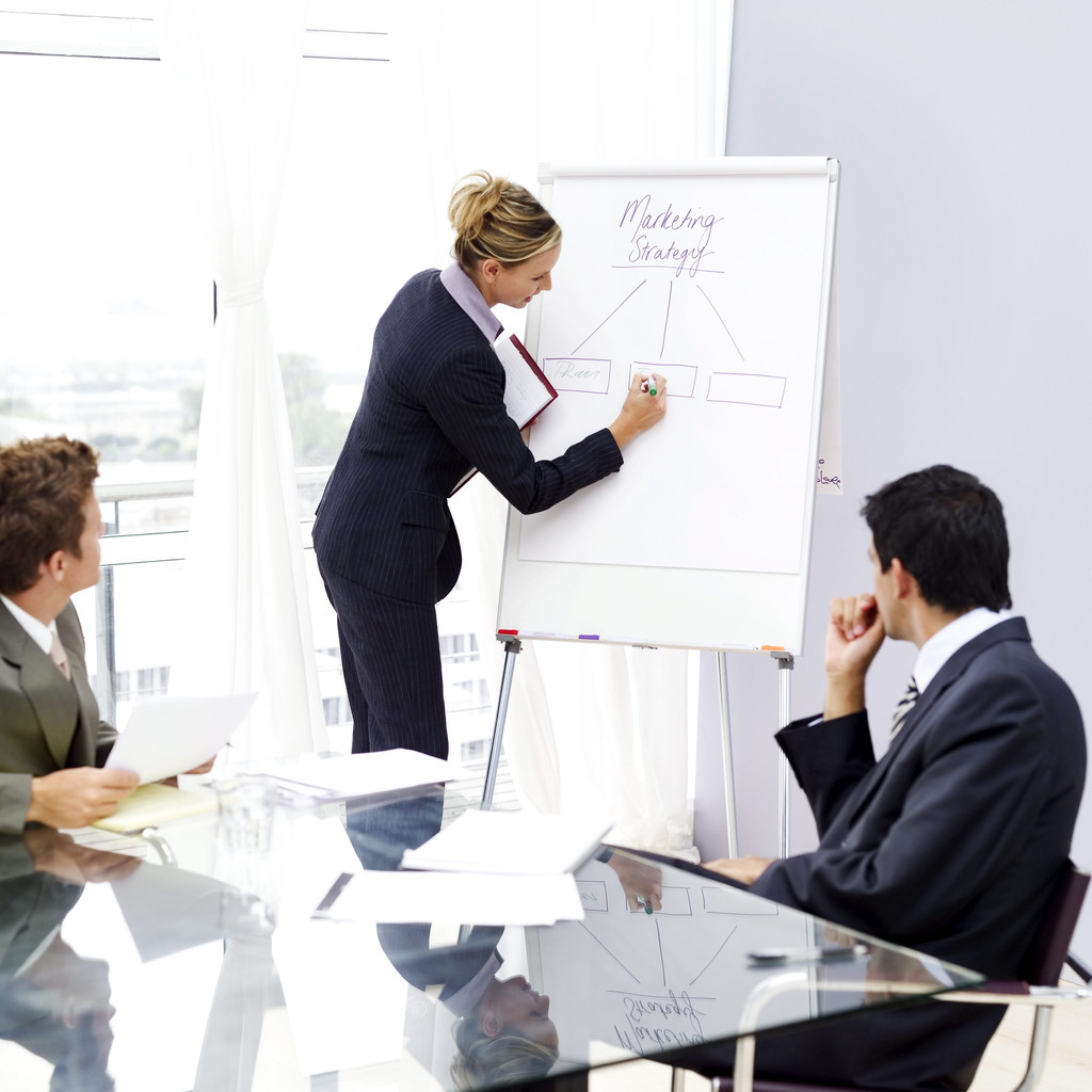 Woman at a meeting writing on a flipchart