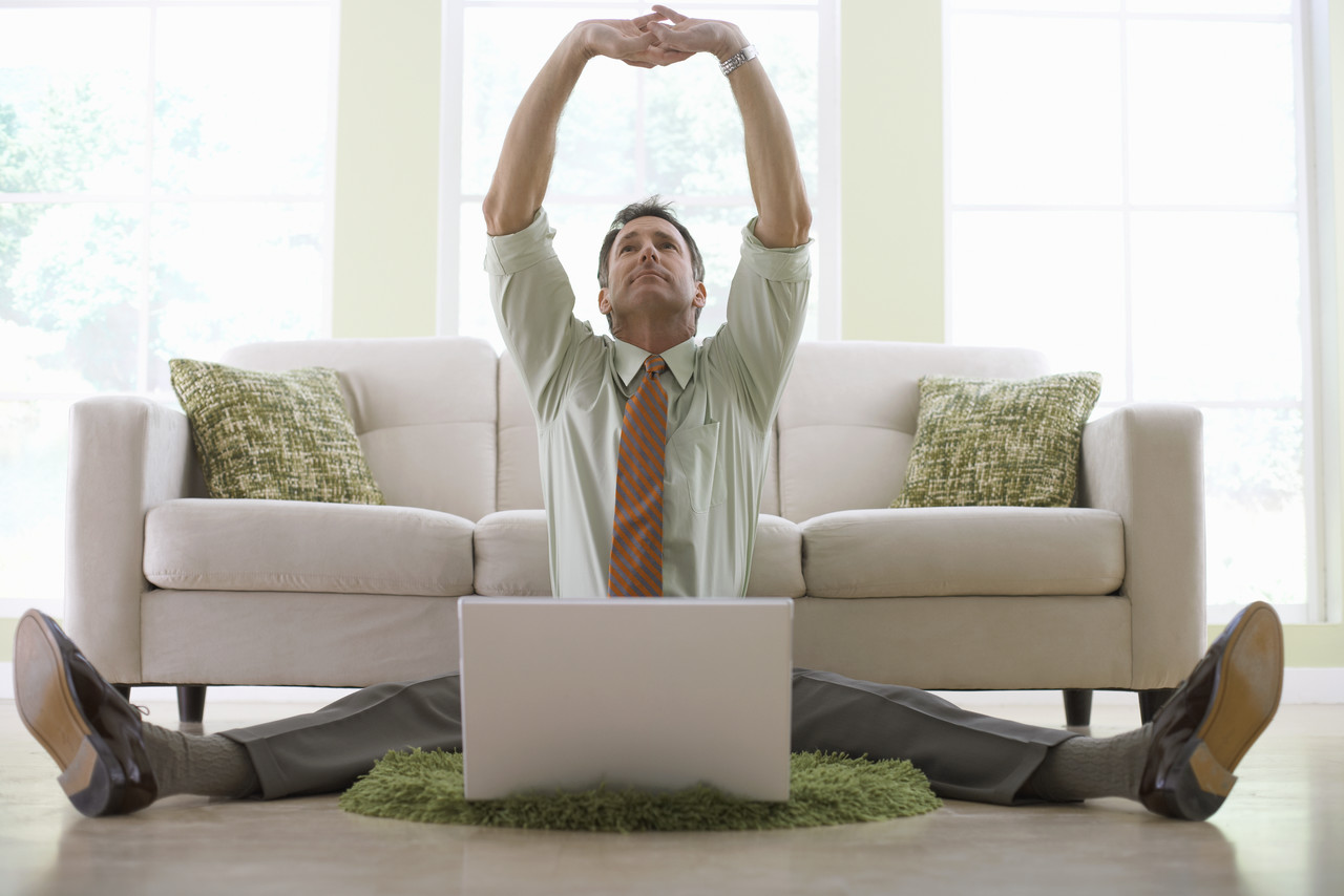 Man sitting happily astride a computer
