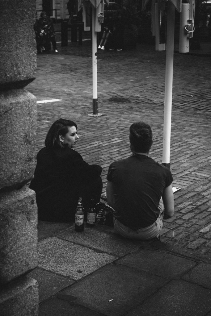 Two people talking at a curb